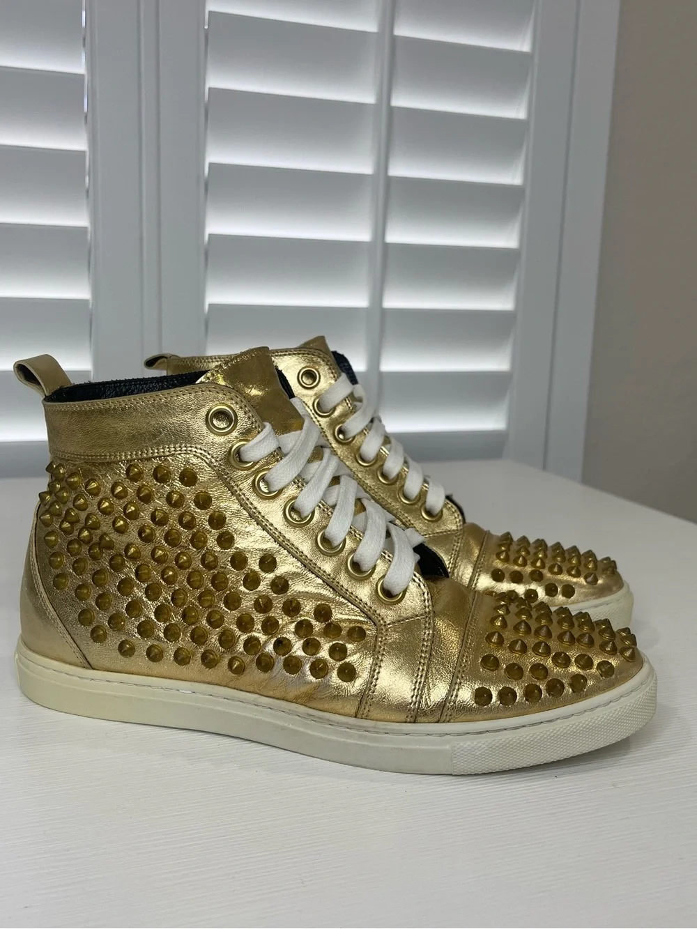 Metallic Gold High-Top Sneakers with Stud Details by Rodney P. Hunt